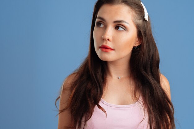 Portrait of a positive nice young woman over a gray background