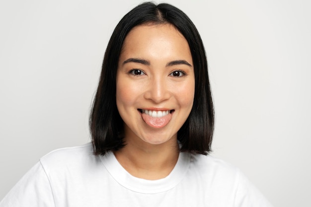 Portrait of positive playful woman standing with tongue out demonstrating childish behaviour