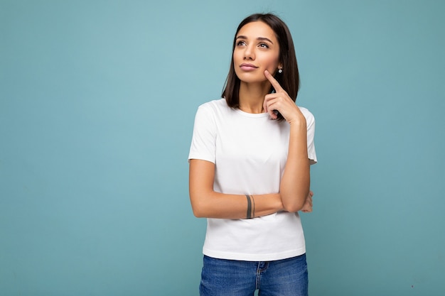 Portrait of positive thoughtful young attractive brunette woman with sincere emotions wearing casual