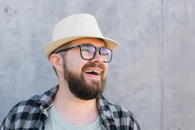 Portrait of positive young hipster man smiling over yellow wall store outdoor background handsome tr