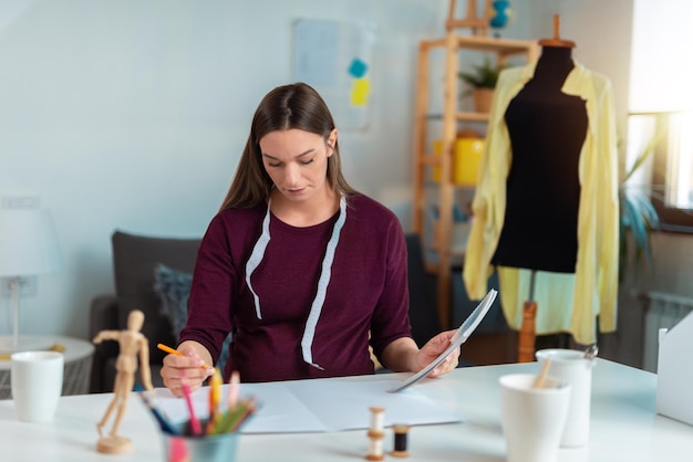 portrait of pregnant professional fashion designer drawing