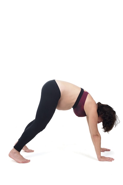 Portrait of a pregnant woman exercising on white, floor exercise