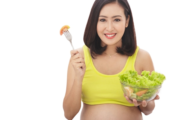 Portrait of pregnant woman holding a bowl of healthy salad