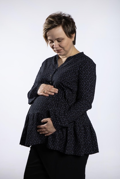 Portrait of pregnant woman Pregnant happy Woman touching her belly making photo session in studio