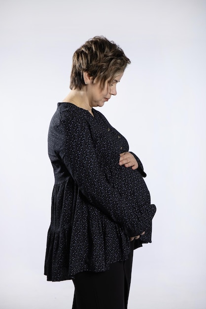 Portrait of pregnant woman Pregnant happy Woman touching her belly making photo session in studio