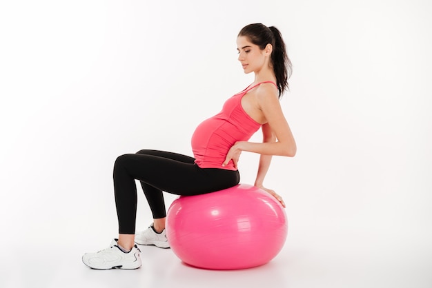 Ritratto di una donna incinta seduta su una palla fitness