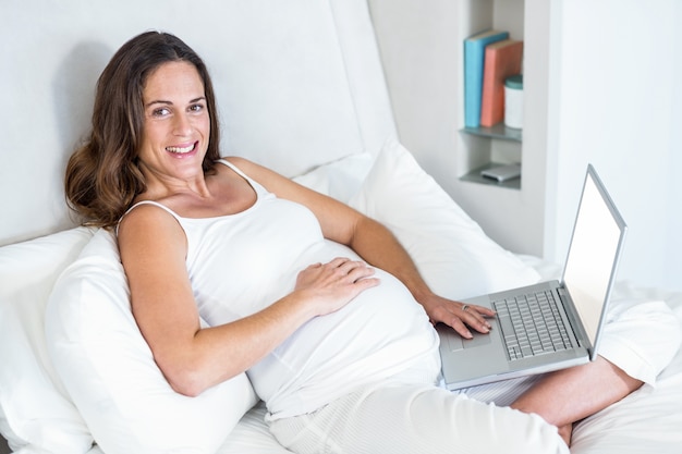 Portrait of pregnant woman with laptop