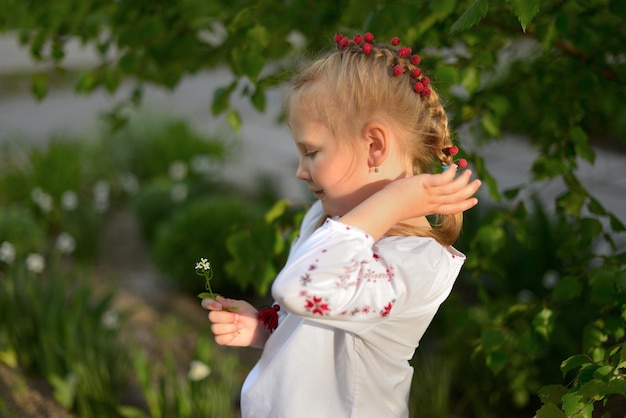 Foto ritratto di una ragazza in età prescolare con un fiore in una camicia ricamata ucraina