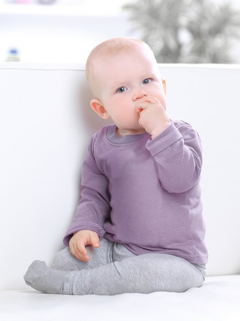 portrait of a pretty baby playing with a ball on the couch