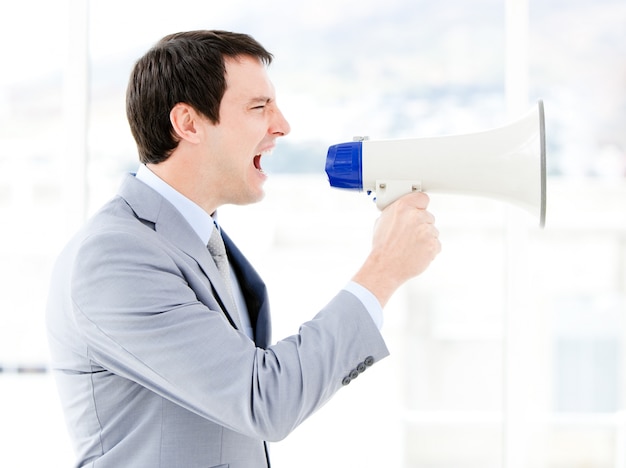 Portrait of an pretty businessman using a megaphone