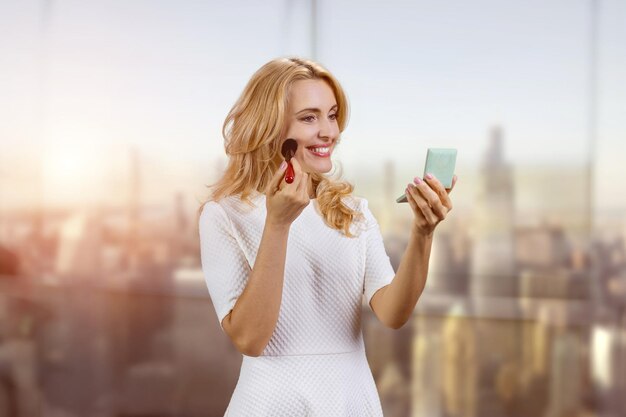 Portrait of pretty caucasian woman making make up urban cityscape background