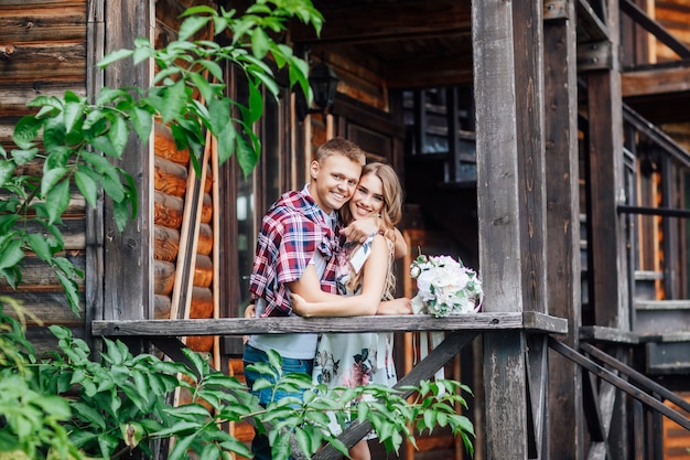 Portrait of pretty couple stay near new house, after buying home and hugging. Honeymoon.