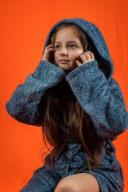 Photo portrait of a pretty girl in a dressing gown posing isolated on an orange background small model concept posing