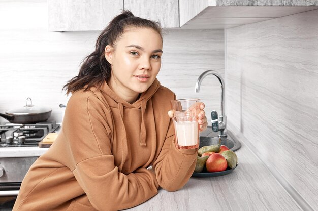 Portrait of a pretty girl drinking milk from a glass