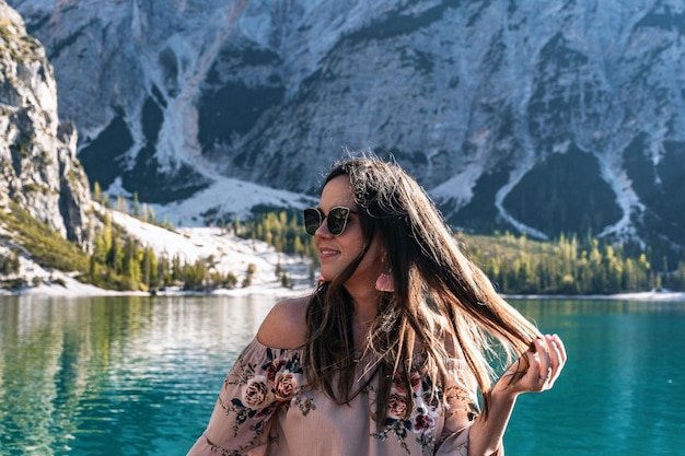 Photo portrait of a pretty girl wearing sunglasses sitting in boat on lake in mountains