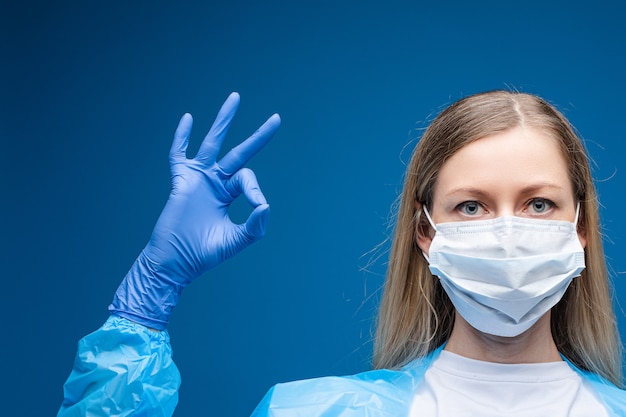 Portrait of pretty girl with long fair hair with medical mask on her face