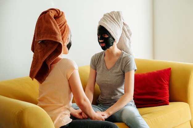 Portrait of pretty joyful girl friends doing beauty treatments at home cheerful young women relaxing.