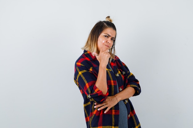 Portrait of pretty lady pointing up in casual shirt and looking angry front view