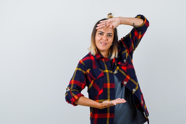 Portrait of pretty lady showing large size sign in casual shirt and looking cheerful front view