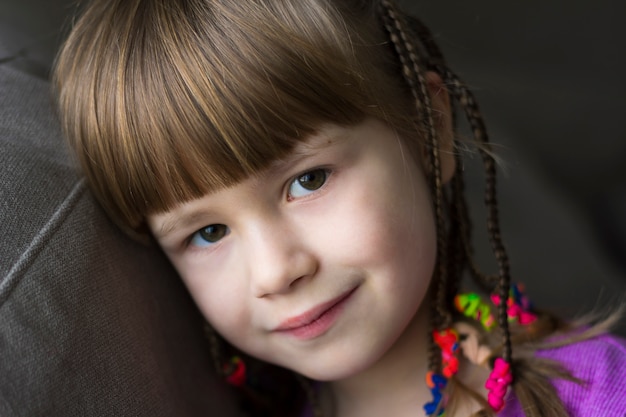 Портрет милой маленькой девочки с маленькими косичками