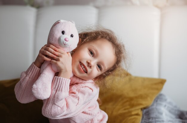 Portrait of a pretty little girl with a soft toy hare. Emotions