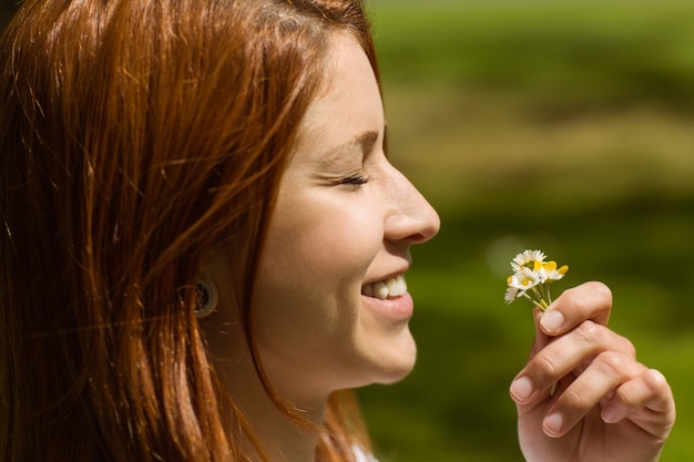 Photo portrait of a pretty redhead holding flowers