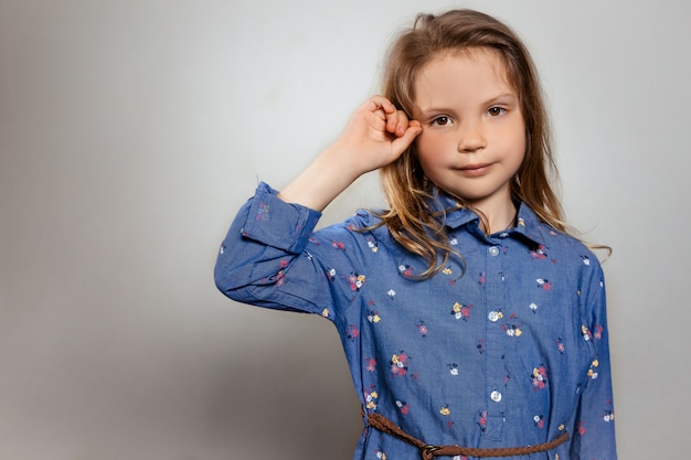 Portrait of pretty smiling little girl in blue dress