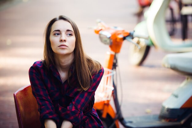 Portrait of pretty smiling woman on scooter