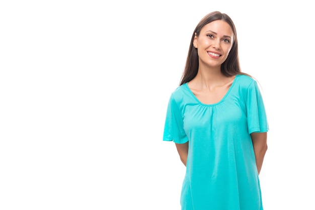 Portrait of a pretty smiling young caucasian brunette woman with long hair in a blue tshirt on a