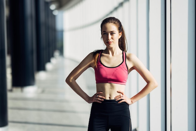 Portrait of a pretty sporty woman standing at gym