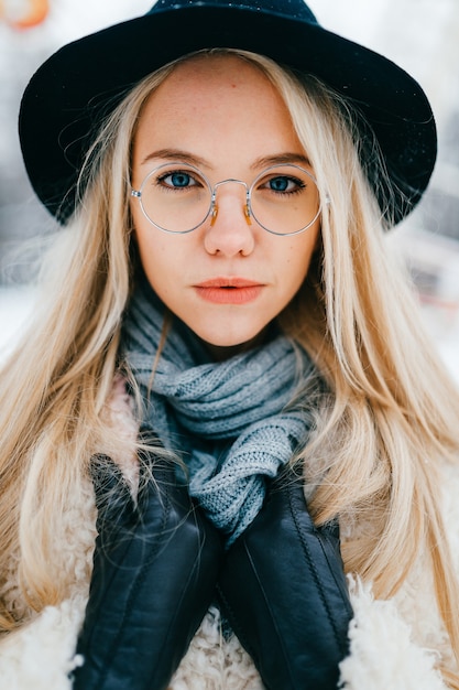 Portrait of pretty stylish blonde girl in hat and glasses