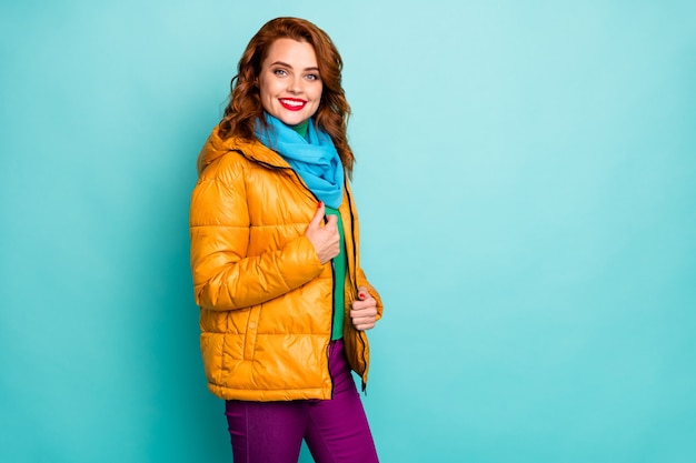 portrait of pretty traveler lady red lips amazing winter day walking down street wear casual yellow overcoat blue scarf violet trousers.