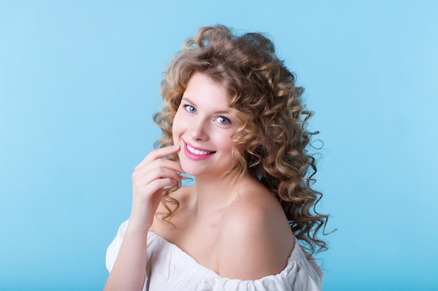 Portrait of pretty woman on a blue wall.