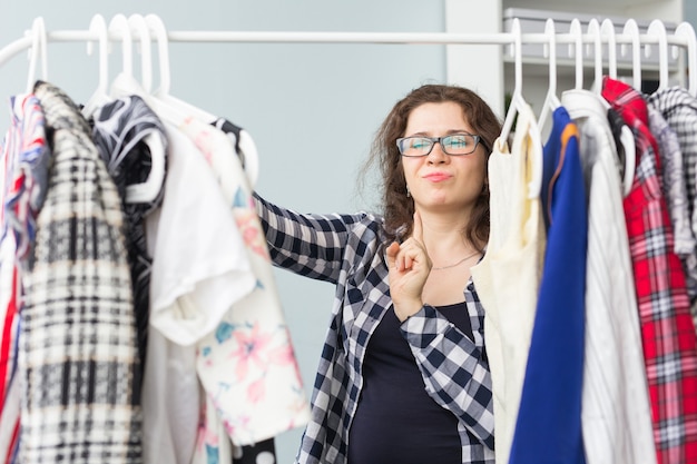 Portrait of a pretty woman looking through the wardrobe