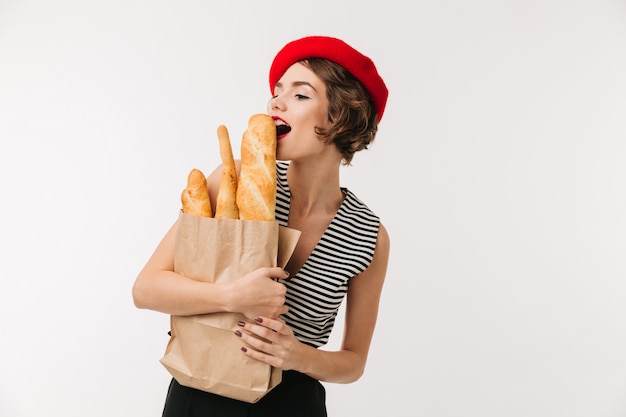 Portrait of a pretty woman wearing beret holding paper bag