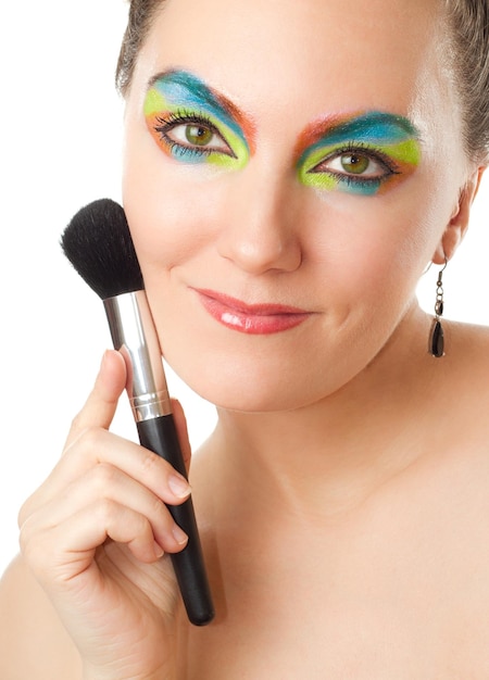 Portrait of pretty woman with professional makeup and brush for powder isolated on white background