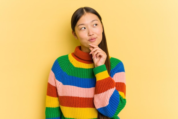 Portrait of pretty young Asian woman isolated on yellow background