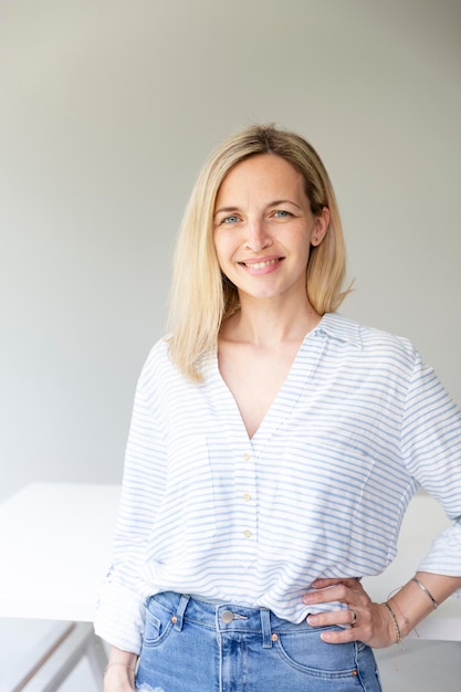 Portrait of pretty young blonde business woman standing by her ergonomic height adjustable work desk in her home office