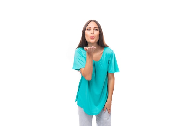 Portrait of a pretty young caucasian brunette woman with long hair in a blue tshirt on a white