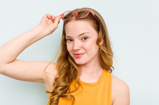 Portrait of pretty young caucasian wearing glasses woman isolated on blue background