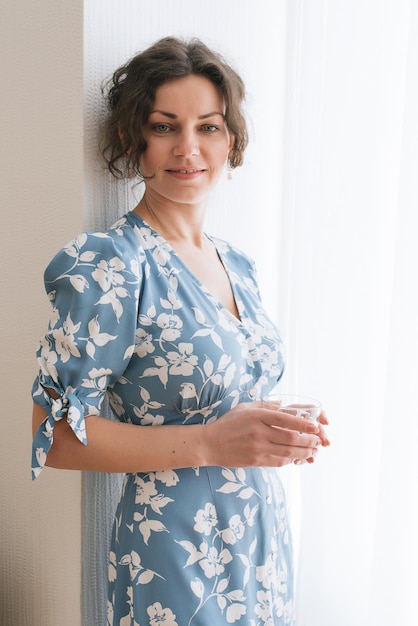 Portrait of pretty young caucasian woman with light natural make up in floral dress