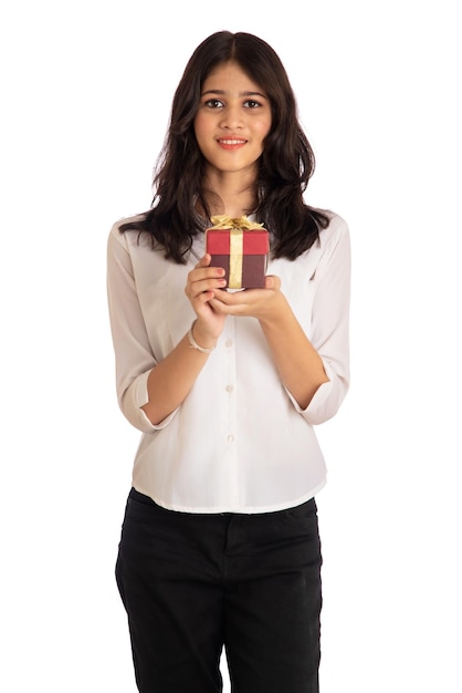 Portrait of a pretty young girl holding and posing with gift box on a white background