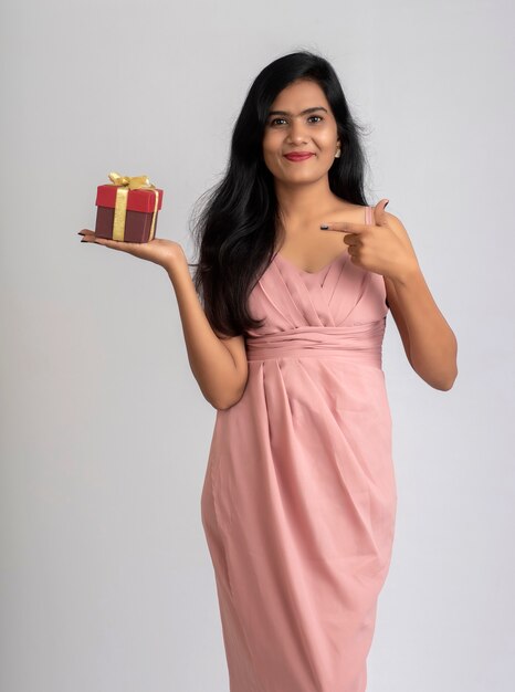 Portrait of a pretty young girl posing with gift box