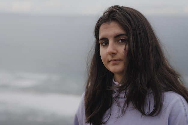 Foto ritratto di una bella ragazza con la spiaggia sullo sfondo