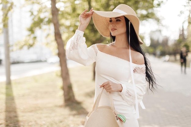 Portrait of a pretty young woman in hat and dress outdoor