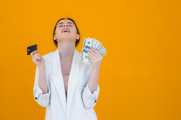 Portrait of a pretty young woman holding credit card at her face