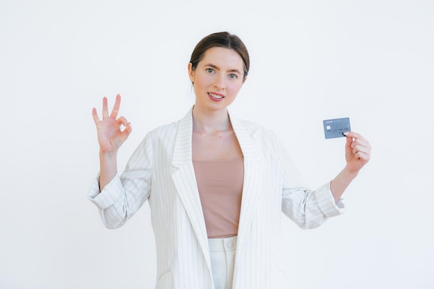Portrait of a pretty young woman holding credit card at her face