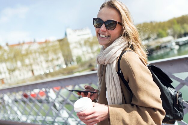 Portrait of pretty young woman looking at camera while walking in the street.