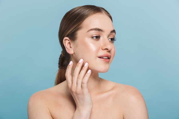 Portrait of a pretty young woman posing isolated over blue wall.