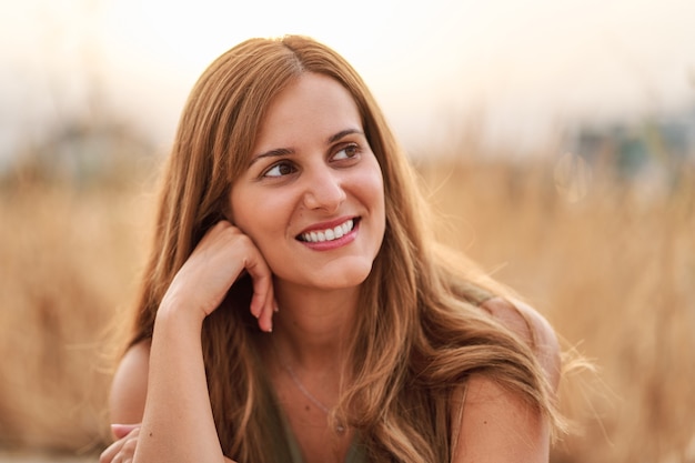 Photo portrait of a pretty young woman smiling with a nice out of focus background.